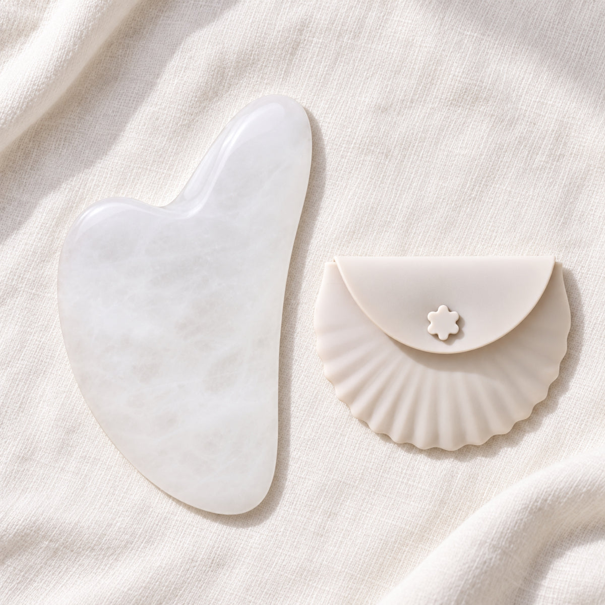 White jade gua sha facial massage tool on a soft neutral background